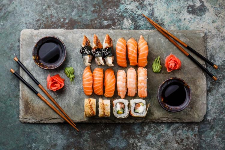 Varied sushi presentation including sashimi and sushi rolls.