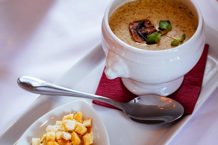 A bowl of creamy mushroom soup with croutons.