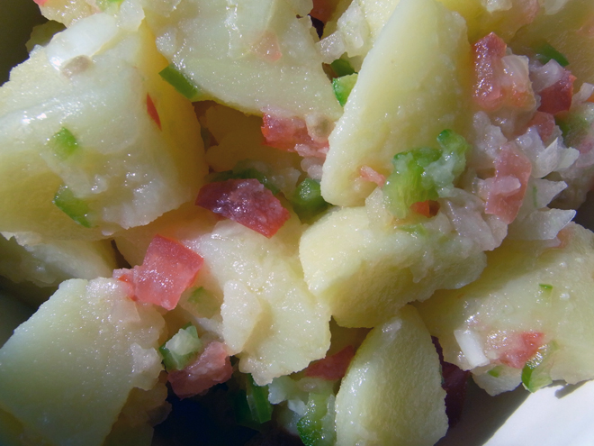 Poato salad with a dressing of vinaigrette wiht finely chopped tomato, bell pepper and onion.