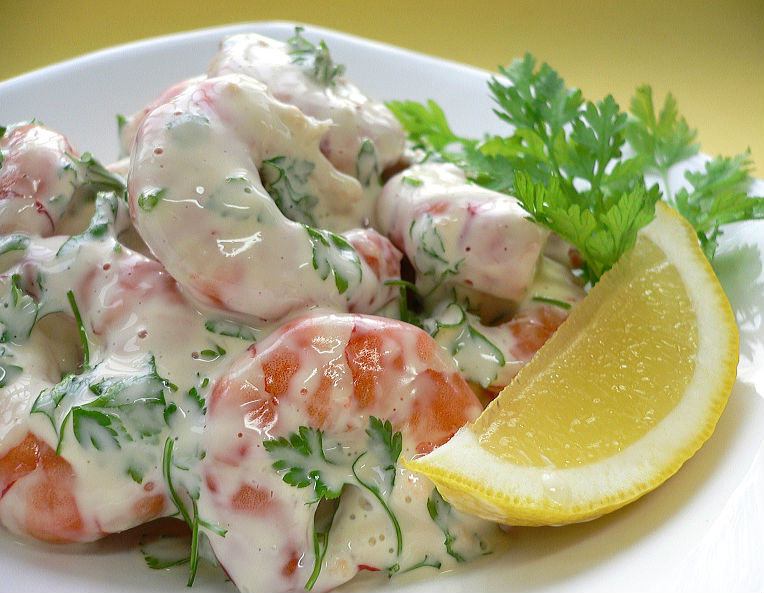 A plate of shrimp salad decorated with chervil.