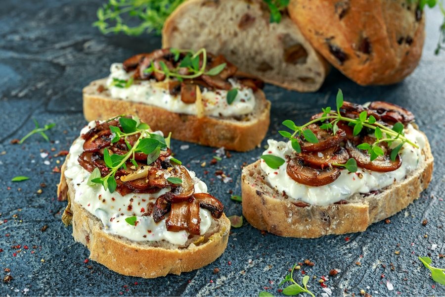 A few toasted bread slices topped with garlic mushrooms.