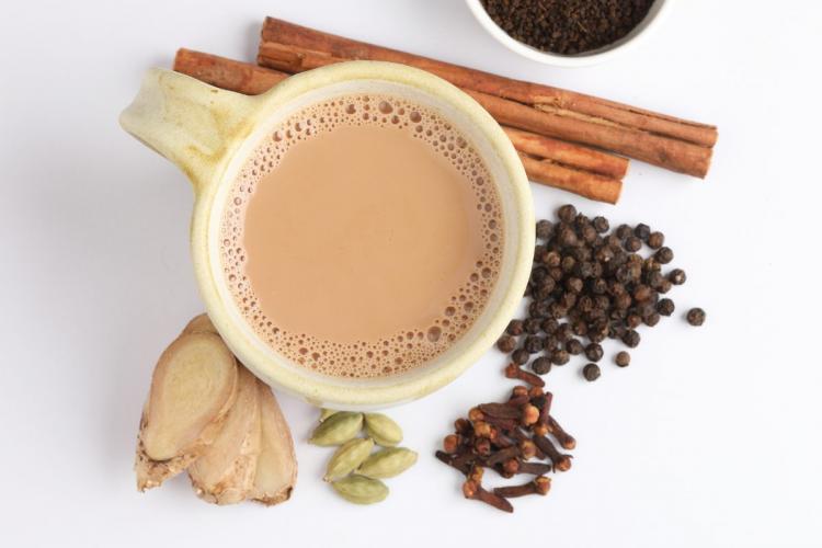 A cupa of masala chai surrounded by spices.