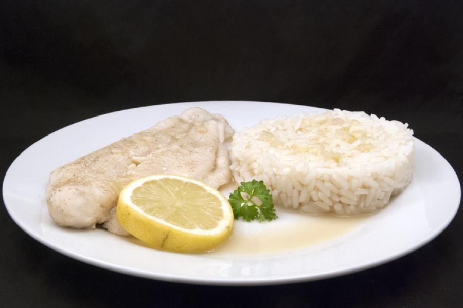 Poached fish fillets on a plate, accompanied with rice.